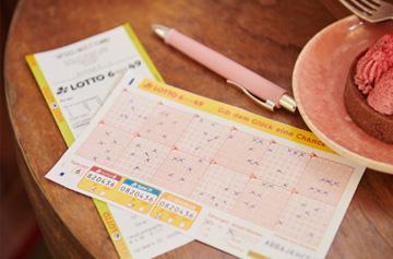 Lotto-Spielschein und -Quittung liegen auf Tisch