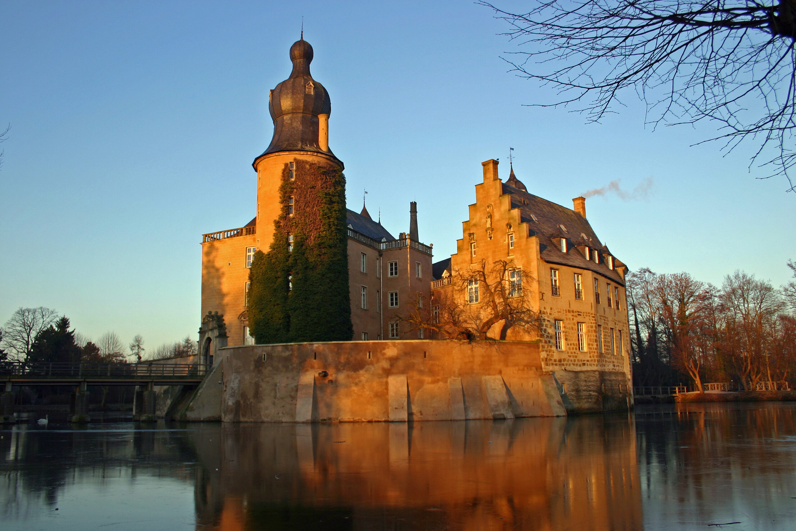 Eine Wasserburg, die von der tiefstehenden Sonne angeleuchtet wird