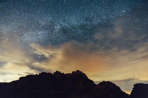 Ein abendlicher Sternenhimmel mit einer dunklen Bergsilhouette.