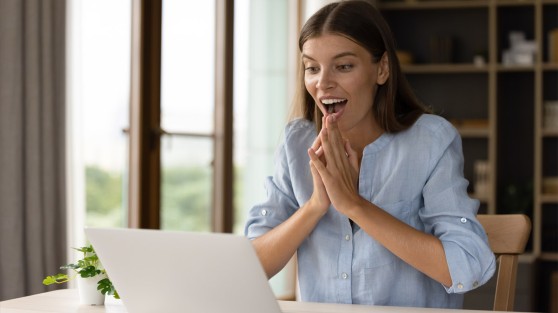 Frau sitzt vor Laptop und freut sich | Eurojackpot-Gewinner NRW