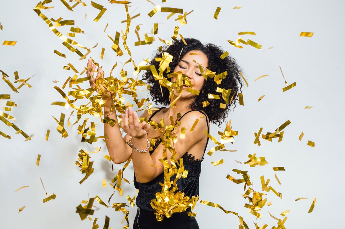 Frau steht im Konfetti-Regen und freut sich | WestLotto Eurojackpot Millionäre