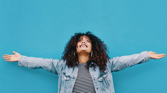 Glückliche Frau mit ausgebreiteten Armen freut sich - Eurojackpot Gewinnerbilanz