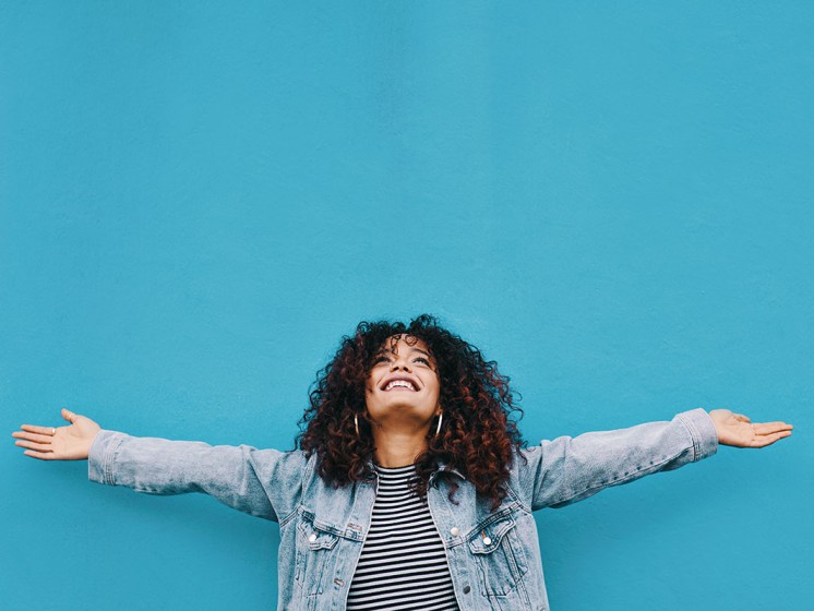 Glückliche Frau mit ausgebreiteten Armen freut sich - Eurojackpot Gewinnerbilanz