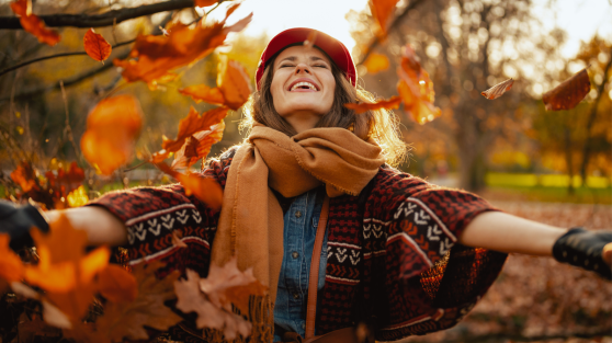 Frau freut sich im Herbstlaub