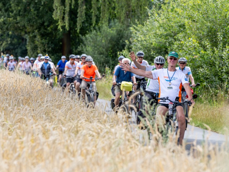 Mehrere Radfahrer fahren einen Feldweg entlang | WestLotto NRW-Radtour 2025