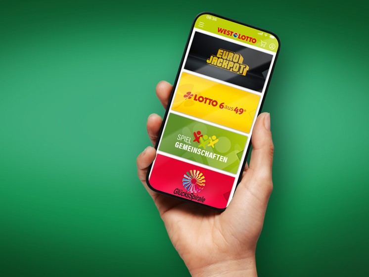 Hand hält Smartphone mit geöffneter WestLotto-App hoch