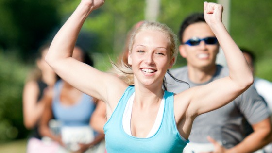 Frau in blauem Sportoberteil jubelt | WestLotto