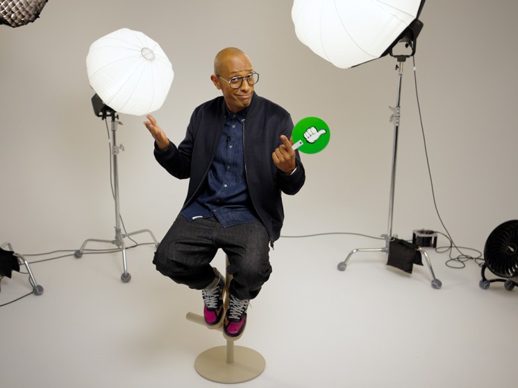 Amiaz - Moderator der Local Hero Bingo-Show - sitzt in einem Studio auf einem Barhocker. WestLotto