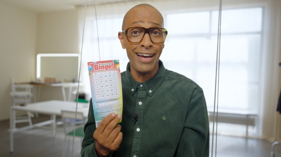 Amiaz Habtu - Moderator der Local Hero Bingo-Show - hält Bingo-Los in der Hand