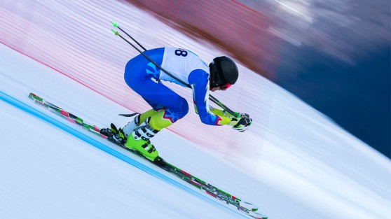 Ein Skifahrer fährt in gebückter Haltung eine steile Piste hinab - WestLotto Sieger-Chance