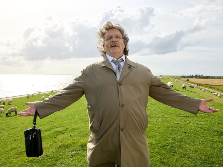 Horst Schlämmer steht auf Wiese und reißt die Arme glücklich auseinander