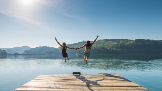 Zwei Personen springen von einem Steg aus in einen See | WestLotto-Ausflugstipps NRW