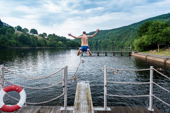 Ein Mann springt von einem Steg in einen See | WestLotto-Ausflugstipps NRW