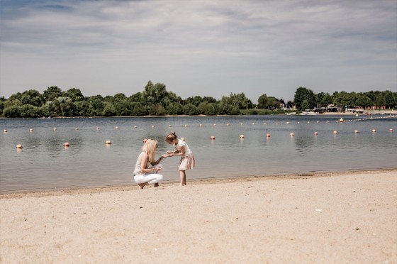 Frau und Tochter stehen am Strand vom Xantener Südsee | WestLotto-Ausflugstipps NRW