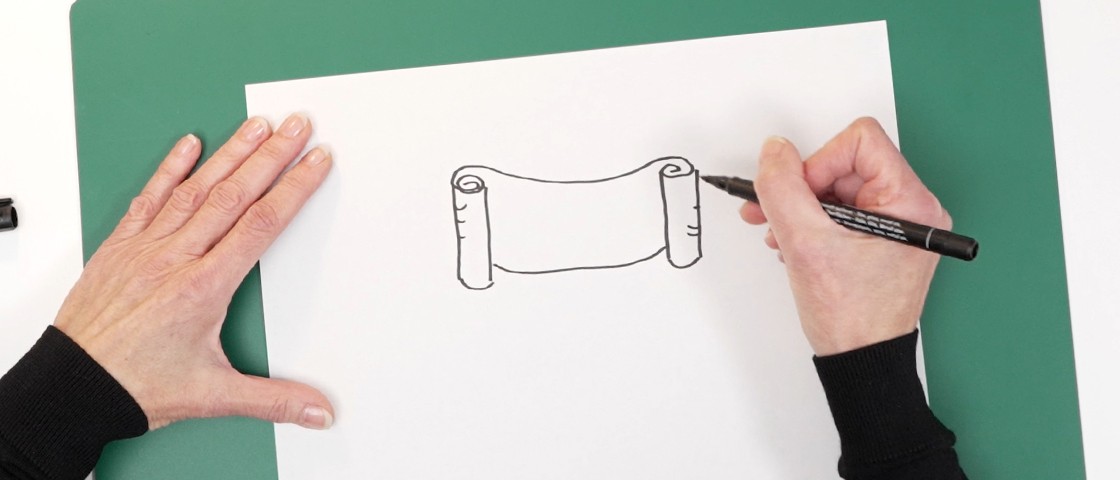 Eine Hand zeichnet ein Banner auf einem weißen Blatt Papier | DIY-Idee Rubbellos
