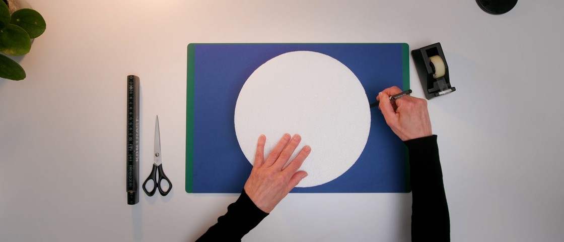 Zwei Hände zeichnen entlang einer Schablone einen Kreis | DIY Rubbellos-Torte