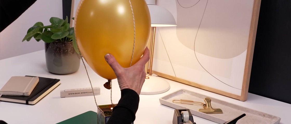 Eine Hand hält einen Luftballon fest