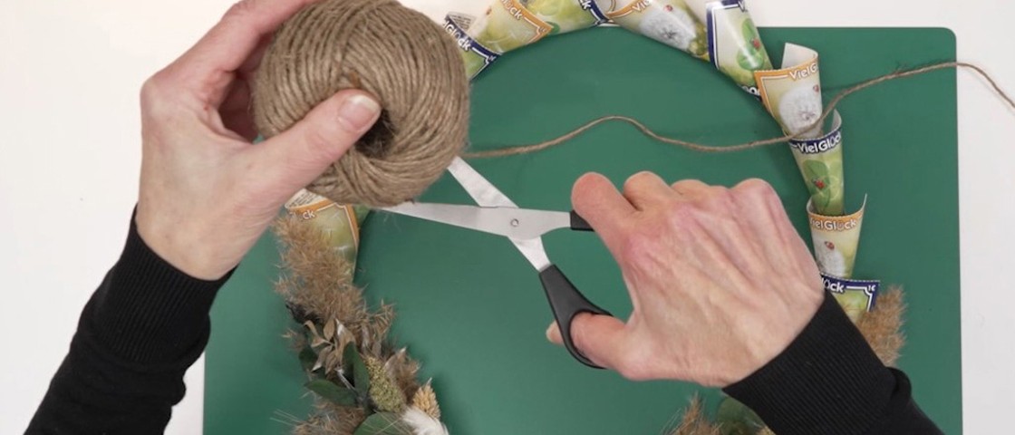 Eine Schere schneidet ein Stück Jutegarn | DIY-Idee WestLotto-Rubbellose