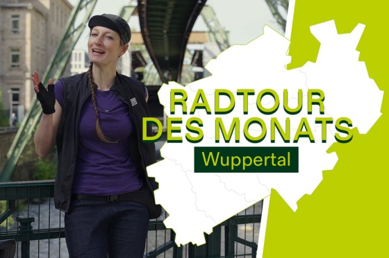 Radfahrerin steht vor Schwebahn in Wuppertal | WestLotto Radtour des Monats