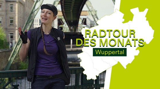 Radfahrerin steht vor Schwebebahn in Wuppertal. Daneben Schriftzug Radtour des Monats - Wuppertal | WestLotto