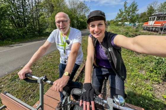 Selfie eines Mannes und einer Frau, die auf Draisine sitzen | WestLotto Radtour des Monats Wuppertal Selfie eines Mannes und einer Frau, die auf Draisine sitzen | WestLotto Radtour des Monats Wuppertal