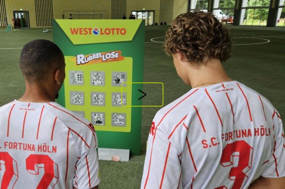 Zwei Spieler der Regionalliga West stehen vor überdimensionalem WestLotto-Rubbellos